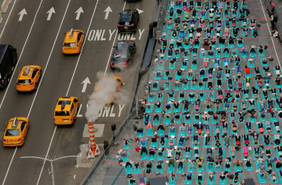 People participate in a yoga class during an annual Solstice event in the Times Square district of New York